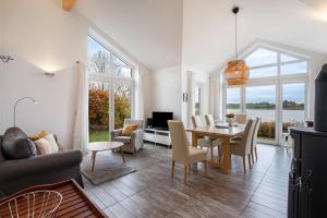 un salon avec une table, des chaises et un canapé dans l'établissement Schwanenuferhaus, à Hestoft