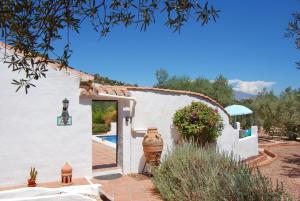 a white house with a door and a yard at Casa The Lofties Mit Pool In Andalusien in Comares