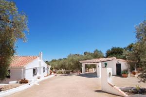 a white house with a gate and a driveway at Casa The Lofties Mit Pool In Andalusien in Comares