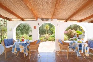 a patio with two tables and chairs and two arches at Casa The Lofties Mit Pool In Andalusien in Comares