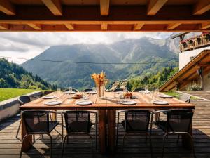 a table on a deck with a view of a mountain at Chalet Ladroit - OVO Network in Les Clefs