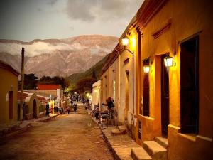 a city street with buildings and mountains in the background at Hostería Los Morteros in Purmamarca +6 photos