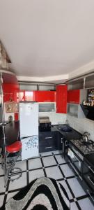 a kitchen with red cabinets and a black and white floor at Khmelnitsky in Zarechʼye