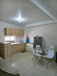 a kitchen with a table and chairs and a refrigerator at Comfy Condo Mactan Cebu in Sampong