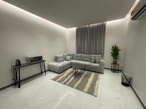 a living room with a couch and a table at جناح عائلي غرفة وصول ذاتي in Al Hofuf