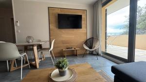 a living room with a television and a table and chairs at Greens View golf saumane in Saumane-de-Vaucluse
