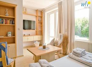 TV a/nebo společenská místnost v ubytování Ferienhäuser Jadehörn Ferienwohnungen Sandfloh Sonnenstern