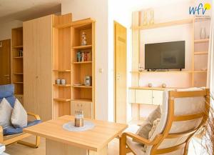 TV a/nebo společenská místnost v ubytování Ferienhäuser Jadehörn Ferienwohnungen Sandfloh Sonnenstern + 8 fotografií