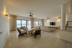 un soggiorno con divano, sedie e TV di Casa Del Mar Villa by YourHost 5B – Nyali Mombasa a Mombasa