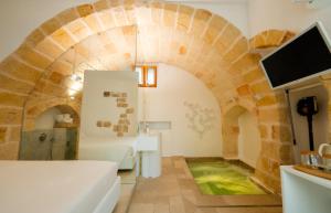 a living room with a couch and a tv at Il Fico Luxury Suite & SPA in Polignano a Mare
