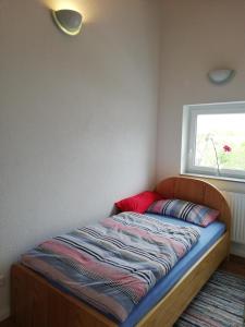 - un lit dans un coin d'une chambre avec fenêtre dans l'établissement Rosensteinferien, à Mögglingen