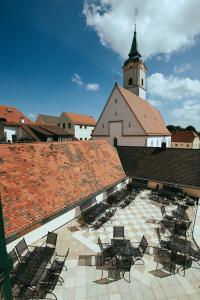 a group of chairs sitting on a roof with a church at Brauereigasthof zum Kuchlbauer in Abensberg