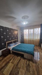 a bedroom with a bed with a blue comforter at Apartament Back in Galaţi