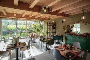 a restaurant with green cabinets and tables and chairs at Casa Margherita Camere & Benessere in Roccaforte Mondovì