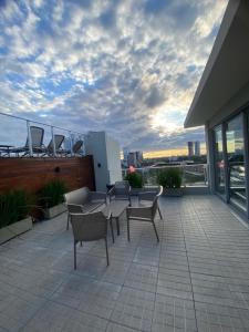 a balcony with chairs and tables on a building at Comfortable 2 Bed Apt Steps From Shopping Del Sol in Colonia Lomas Valentinas