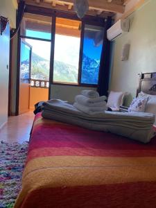 a bedroom with a large bed with towels on it at The Imlil escape Retreat in Tamatert