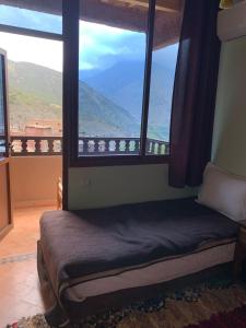 a bedroom with a large window with a view at The Imlil escape Retreat in Tamatert