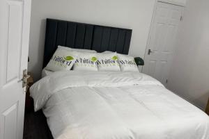 West BoldonにあるBungalow - Sleeps 2 - Parking - Gardenの白いベッド(黒いヘッドボード、枕2つ付)