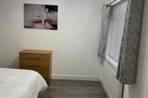 a bedroom with a bed and a dresser and a window at Bungalow - Sleeps 2 - Parking - Garden in West Boldon