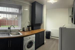 West BoldonにあるBungalow - Sleeps 2 - Parking - Gardenのシンクと洗濯機付きのキッチン