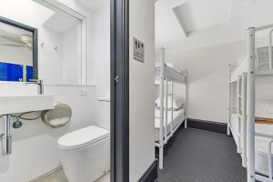 a white bathroom with a toilet and a sink at London Gate Backpackers Hotel in Sydney
