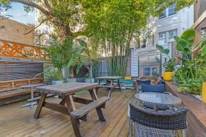 a patio with tables and chairs and trees at London Gate Backpackers Hotel in Sydney