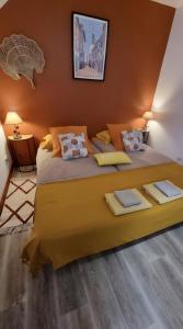 ein Schlafzimmer mit einem großen Bett mit gelber Bettwäsche in der Unterkunft Gîte Les Hervelines in Le Val Hervelin