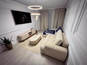 a living room with a couch and a bed at Boutique Apartment 2 in Ploieşti