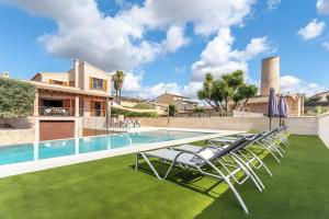 a pool with lawn chairs and a house at Chalet Bonavista in Sineu