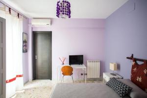 a bedroom with a bed and a desk with a television at Attiko B&B in Palazzolo Acreide