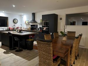 eine Küche mit Holztisch und ein Esszimmer in der Unterkunft Villa Mimosa - 5 voyageurs in Le Moutchic