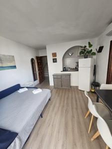 a room with a bed and a refrigerator and a table at Le Mirage Ibiza in San Antonio