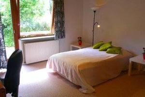 Un dormitorio con una cama con almohadas verdes y una ventana en Villa Sø, en Odense