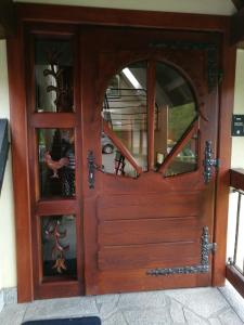 een toegangsdeur naar een huis met een houten deur bij Apartament z kogutem in Zakopane