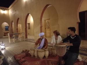 a group of people in a room with pottery at Hotel Berber Palace Merzouga in Hassilabied