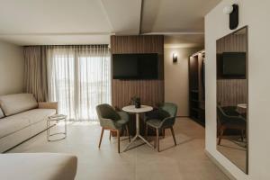a living room with a couch and a table and chairs at Regional Hotel by NEU Collective in Il-Gżira
