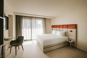 a hotel room with a bed and a chair at Regional Hotel by NEU Collective in Il-Gżira +27 photos