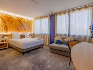 a hotel room with a bed and a couch at Mercure Lyon Est Villefontaine in Villefontaine +113 photos