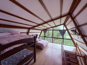 a bedroom with two beds in a room with a large window at Finca de Descanso El Ocaso in Sevilla +32 photos
