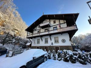 a snow covered house with a bus in front of it at Ferienwohnungen Schweizerhaus in Dresden