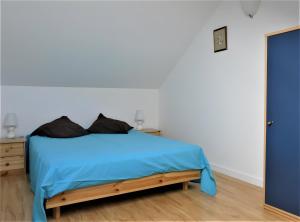 ein Schlafzimmer mit einem Bett mit einer blauen Decke in der Unterkunft Au Fil Du Réguinier - Gîte Briançon in Forville