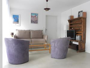 ein Wohnzimmer mit Couch und Schreibtisch in der Unterkunft Au Fil Du Réguinier - Gîte Briançon in Forville