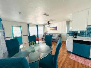 a kitchen and living room with a glass table and chairs at Playa Esmeralda Cottage! Add Golf Cart!! in Bradenton Beach