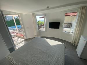 a bedroom with a bed and a balcony with a television at Gönül Evim in Bogazici