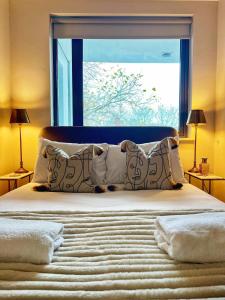 a bedroom with a large window and a bed with pillows at Stylish 2BR Flat in Central Liverpool with Parking in Liverpool