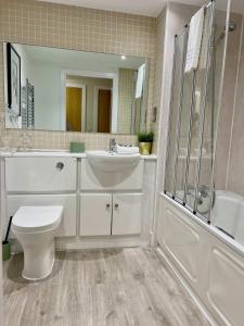 a bathroom with a sink and a toilet and a tub at Stylish 2BR Flat in Central Liverpool with Parking in Liverpool