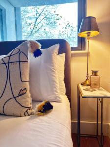 a bed with a pillow and a lamp and a window at Stylish 2BR Flat in Central Liverpool with Parking in Liverpool