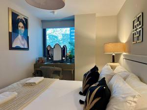 a bedroom with a bed and a desk and a window at Stylish 2BR Flat in Central Liverpool with Parking in Liverpool +9 photos