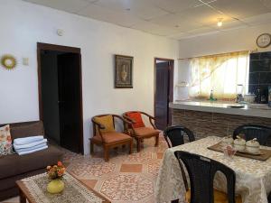 una sala de estar con un sofá, una mesa y sillas en Los Tamarindos Posadamanabita, en Portoviejo