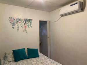 1 dormitorio con 1 cama y aire acondicionado en la pared en Los Tamarindos Posadamanabita, en Portoviejo
